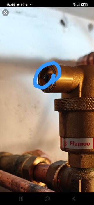 Närbild av en mässingsventil med ett område markerat i blått som visar en spårskruv som kan användas för att stänga av läckage.