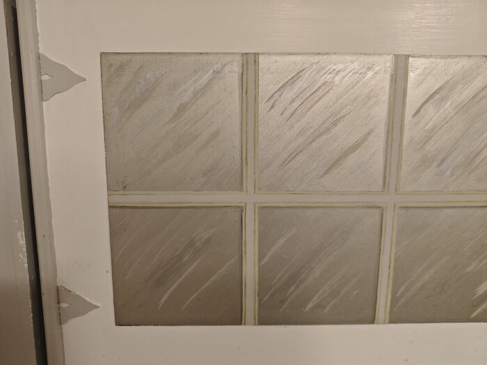 Träskåpsdörr med målad yta och glaspaneler, snickarglädje i hörnet, potentiellt lagad och med målade ränder.