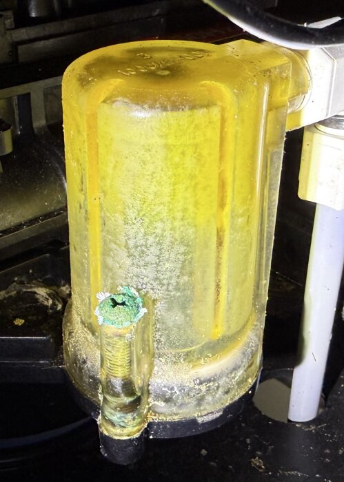 Gult filter med smutsig yta i ett pumprum, del av vattensystem för hus med egen brunn.