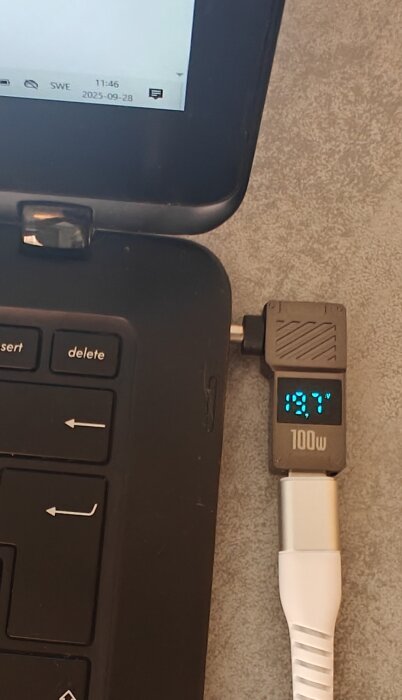 Laptop med ansluten PD-trigger och display som visar 19.7V och 100W kapacitet.