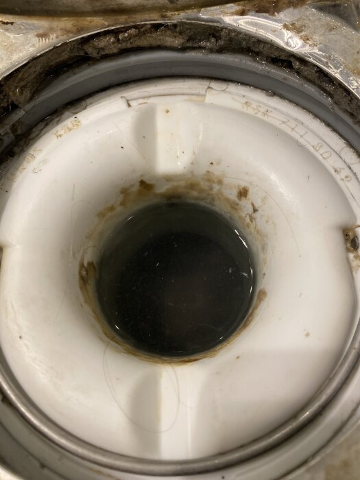 Avloppsbrunn med klämring och spår av smuts eller mögel under monteringen.