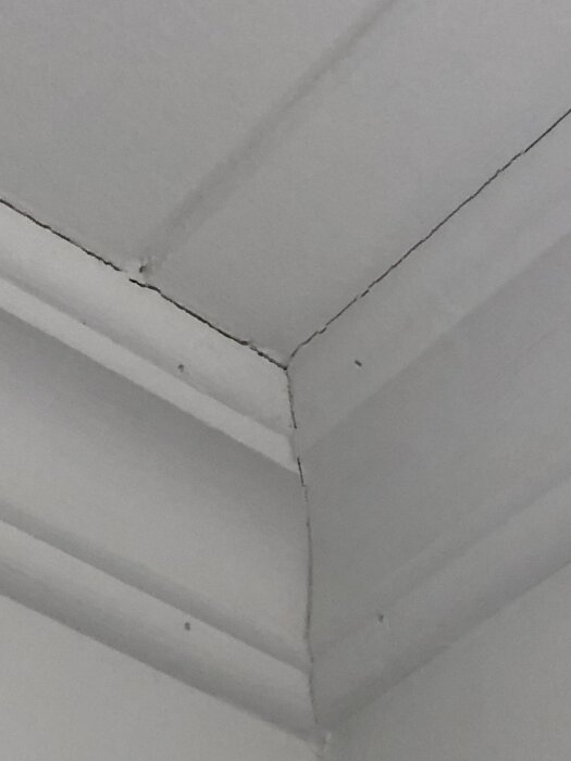 Taklist med synliga sprickor i hörn.