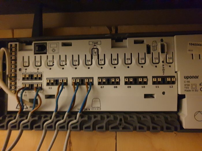 Elektrisk kopplingspanel för Uponor C-56 kontrollenhet med märkningar och kablar anslutna.