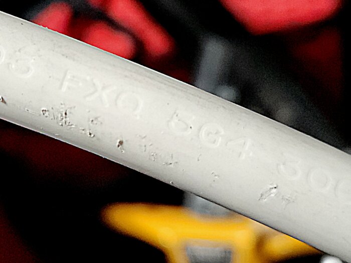 Närbild på vit kabel med präglad text, använd för att montera en laddbox.