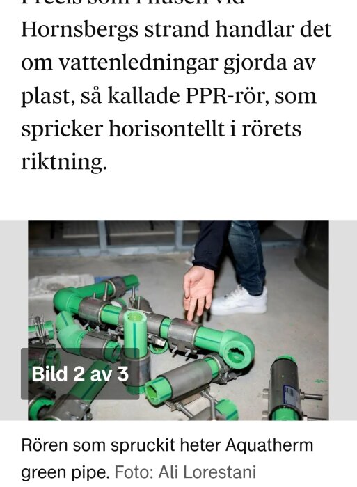 Gröna PPR-rör med monterade kopplingar ligger på golvet; en person pekar mot dem.