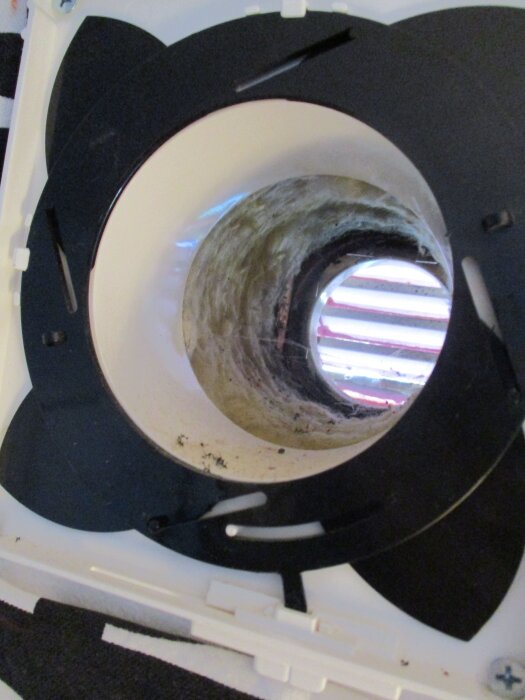 Ventil i en vägg utan genomgående rör, med synlig isolering och ett reglage för luftflöde, sedd från insidan.