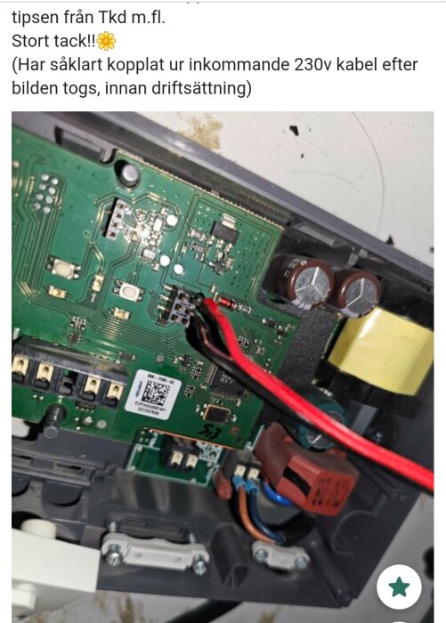 Kretskort med ledningar och komponenter inklusive röda och bruna kablar, nära en transformator inuti en apparat.