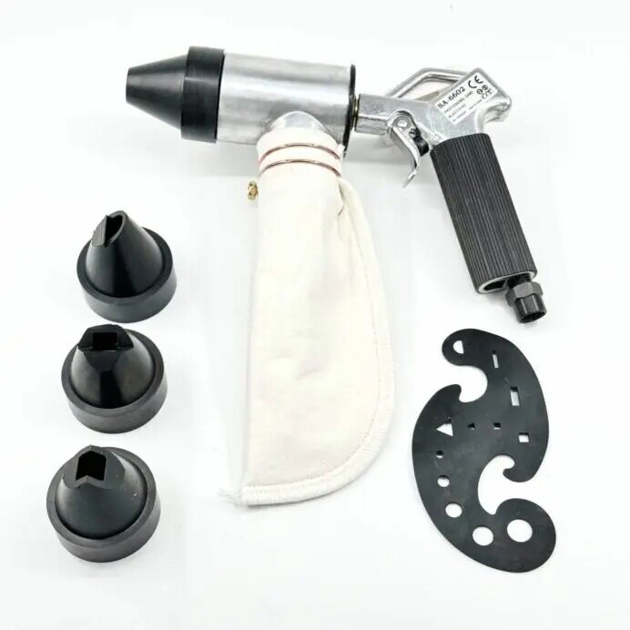 Blästerpistol med avtryckare, vit filterpåse och tre svarta munstycken samt en svart platta.