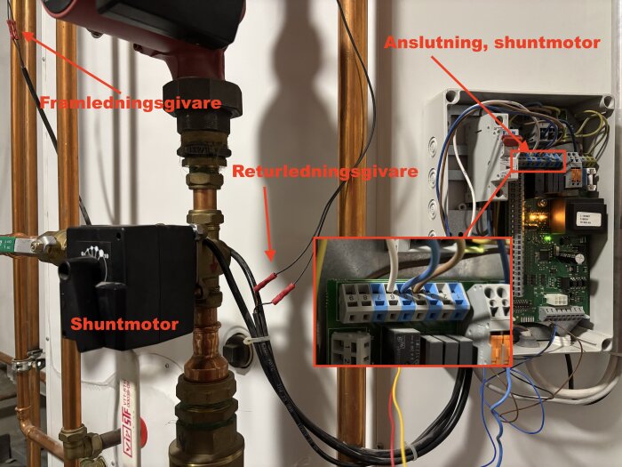 Närbild av en bergvärmeinstallation med shuntmotor, framlednings- och returledningsgivare, samt inkopplingsdetaljer i en elektronikbox.