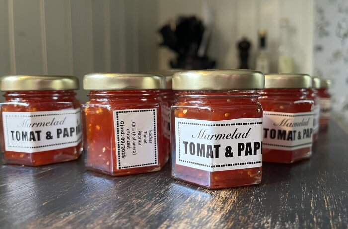 Tomat- och paprikamarmelad i små glasburkar med etiketter, perfekta som julklappar.