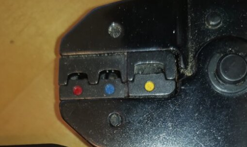 Verktyg med tre fack markerade med röda, blåa och gula symboler, där mittenfacket ser ut att ha "tänder".