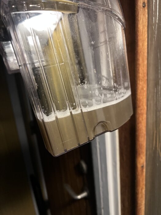 Behållare med smutsigt vatten från klädseltvätt i bilsanering.