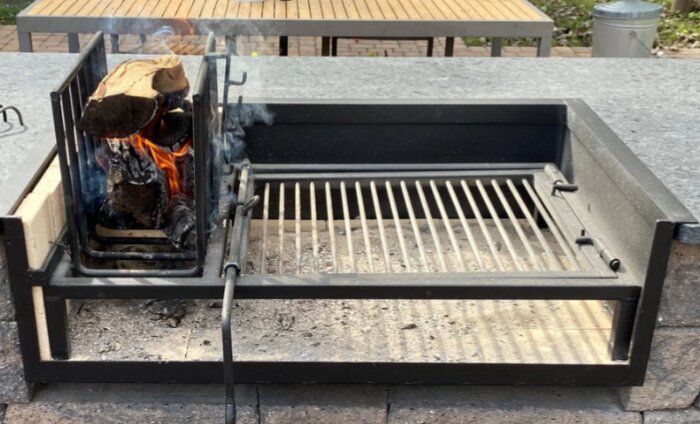 Smidd grill med eldningskorg till vänster, glöden sprids under galler, perfekt för att justera temperatur. Ett projekt inspirerat av sydamerikansk design.