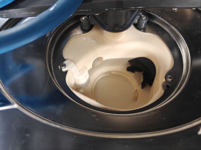 Närbild av insidan av en diskmaskin, visar delen där tryckgivaren är monterad. En blå slang ses överst i bilden.