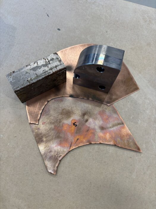 Kopparplåt med märken och två metallblock, del av projekt för gnistskydd.