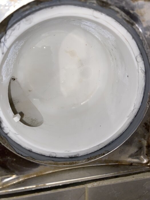 Inre del av ett avloppsrör med fuktfläckar och kantrester, potentiellt för bedömning av Anticimex.