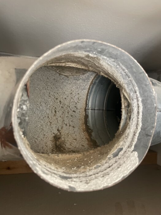 Ventilationsrör med synlig smuts och avlagringar inuti, ifrågasatt om detta utseende är normalt.