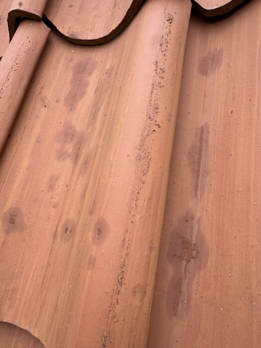 Närbild av Monier Vittinge tegelpannor med ojämn yta och fläckar, vilket illustrerar deras skörare och porösare kvalitet.