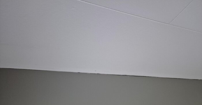 Spricka mellan vägg och tak i sovrummet, olistad, potentiell källa till kalluft som kan påverka isoleringen och rumstemperaturen.