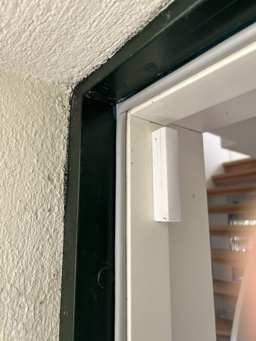 Närbild på en dörrkarm med gummilist monterad, visar konstruktionen och hur listerna möts för att säkerställa en tät förslutning mot kylan.