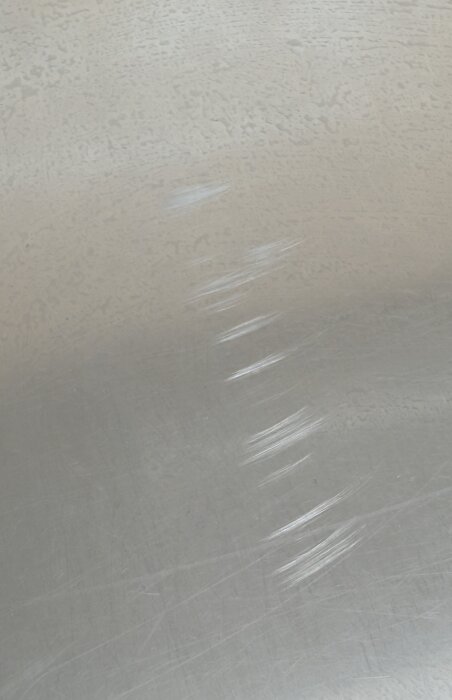 Repor på rostfri bänk orsakade av en slipmaskin som inte stannat.