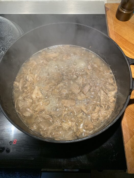 Karré puttrar i en gryta på spisen, kokt i cola, ska smörjas med BBQ-sås för att bli carnitas.