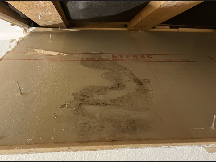 Fuktskadad gipsskiva i takkupa med missfärgningar och skador synliga.