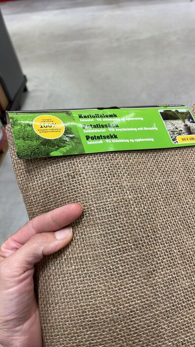 Jute sack labeled for covering and storage, held in hand; part of DIY slip casting project preparation.