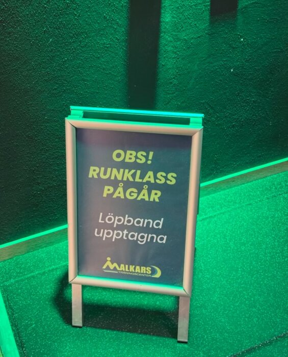 Skylt vid träningscenter som varnar om att löpband är upptagna på grund av pågående löpklass.