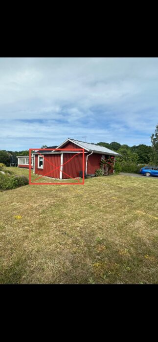 Röd sommarstuga i Blekinge med sektion markerad med rött kryss, som inte behöver ny panel enligt offert för fasadbyte och renovering.