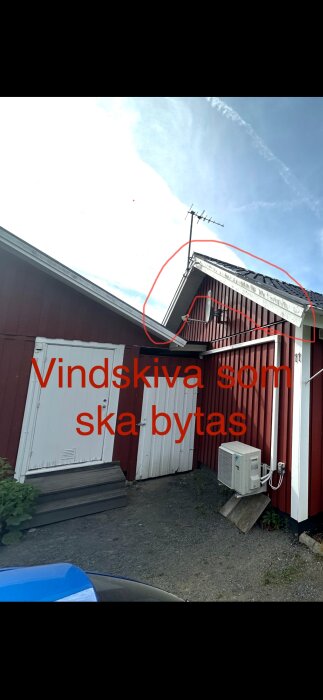 Tak med röd fasad där en vindskiva är markerad i rött för byte, två vita dörrar och en luftvärmepump syns också.