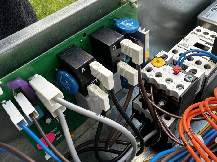 Elskåp med kablar och komponenter, eventuellt mjukstartskort med limmarkeringar och misstänkta brända delar, relaterat till motorskyddslarm 07.