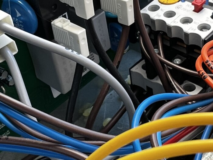 Elektriska ledningar och komponenter i en mjukstartskrets, med gul substans (lim) på en bottenplatta, potentiellt orsak till brända komponenter.