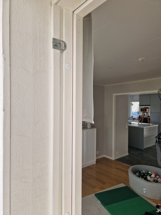 Öppning till altandörr med borttagna lister, tidigare fästa med häftklammer. Synlig interiör i bakgrunden och cirka 3.5 mm springor.