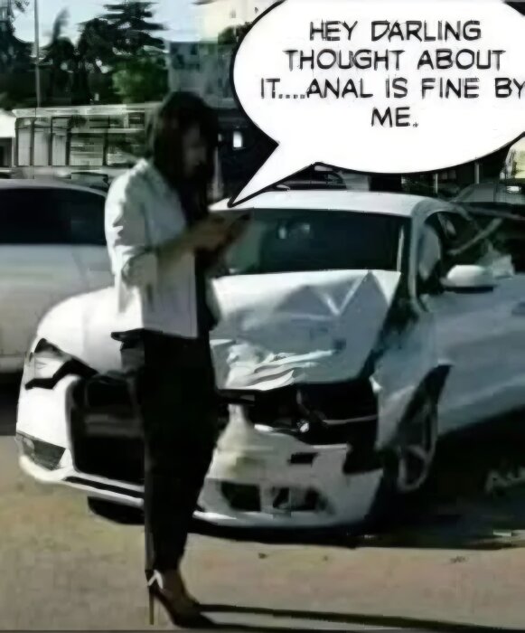 Kvinna står vid en kraschad bil och läser något från sin telefon.