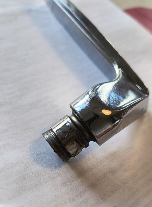 Metallhandtag med urspårad del och synlig metallring avsedd för låshus.