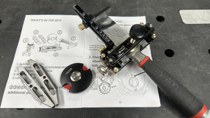 Hongdui HD29 slipjigg med mätanvisningar och komponenter, inklusive skärverktyg och instruktioner, på arbetsbänk.