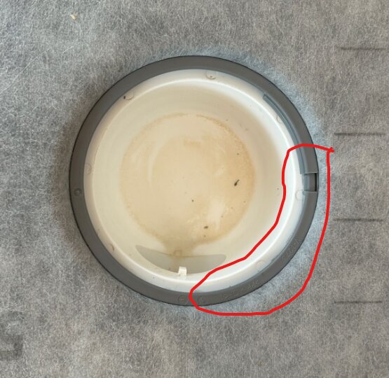 Närbild på klämring monterad mot en yta, med en röd markering där något tycks sticka ut under ringen.