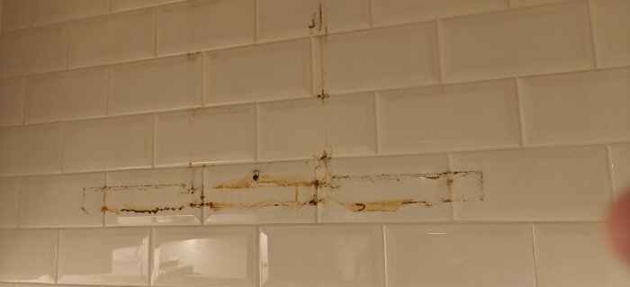 Smutsfläckar och rester på kökskakelvägg efter nedmontering av köksfläkt.