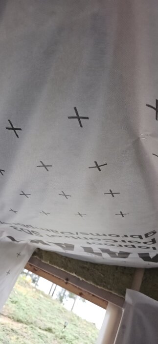 Ångbroms installerad under isolering i en friggebod, där isoleringen sviktar nedåt på grund av dess längd.