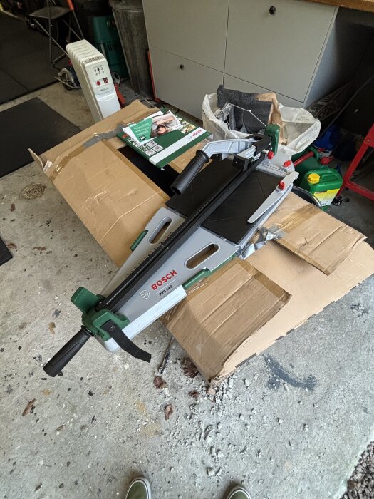 Klinkerskärare av märket Bosch FTC 640, placerad på en kartong i ett garage, omgiven av verktyg och förpackningar.