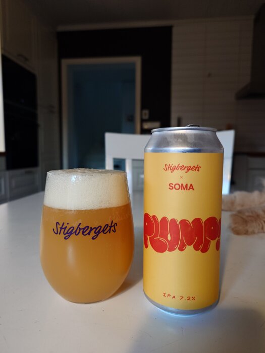 En öl från Stigbergets med etiketten "PLUMP!" stående bredvid ett glas öl på ett bord i ett kök.