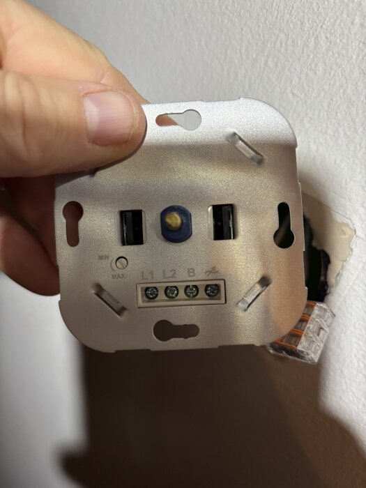 Led-dimmer utan nolla visar kopplingsschema med L1, L2 och B. Person håller dimmern framför väggen.