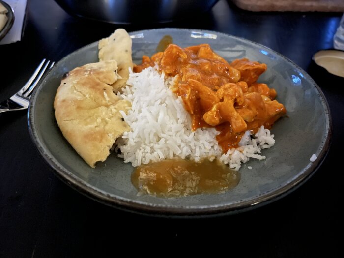 Tallrik med Tikka Masala, kyckling, blomkål, ris, naanbröd med vitlökssmör och mango chutney.