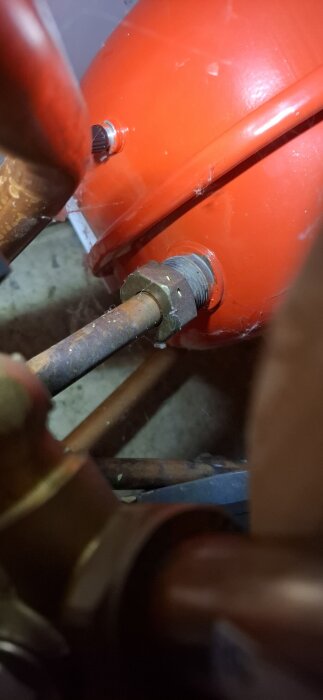 Rött expansionskärl med kopparrörsanslutning.