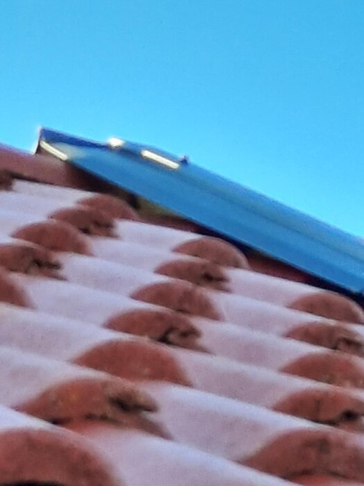 Närbild av ett tak där takplåt skapar en öppning vid vindskivans högkant.