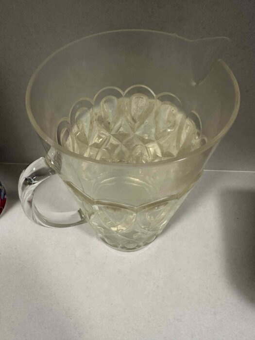 Kanna med gulaktigt vatten som visar på järnföroreningar, vilket orsakar missfärgning och metallisk smak enligt inlägg.