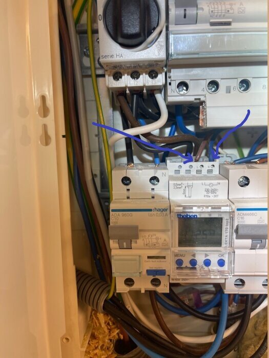 Elcentral med säkringar och timer. Blå och bruna ledningar pekas ut för mätning av spänning, mål 210-240VAC.