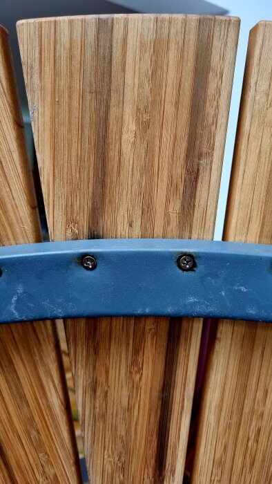 Närbild av trädgårdsbord i stavlimmad bambu med utfällningar nära skruvhål och metallstöd.