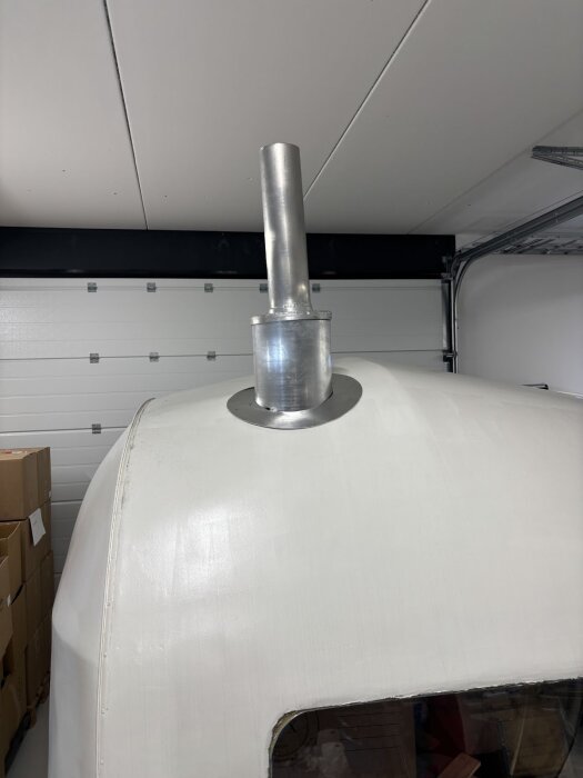 Aluminiumskorsten monterad på ett rundat tak, del av ett byggprojekt.